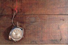 7964762-old-watch-hanging-on-fish-hook-with-red-thread-on-wooden-background.jpg