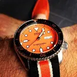 Seiko_diver_watch_on_a_black_white_and_orange_NATO_strap_nylon_replacement_watch_band_1_1024x...webp