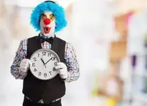 payaso-cara-graciosa-sujetando-reloj_1149-465.webp